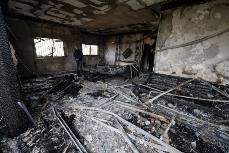 A Palestinian man inspects the remains of a burnt out home following a reported attack by Israeli settlers in the village of Deir al-Hatab, east of the city of Nablus, in the Israeli-occupied West Bank on March 23, 2026.