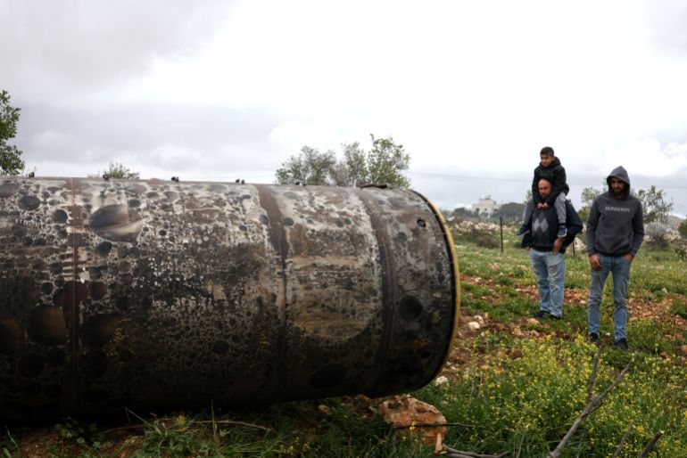 afp_69c613311ef5-1774588721 Palestinian residents inspect the remnants of an missile that landed in the Israeli-occupied West Bank village of Beitin, northeast of the city of Ramallah on March 26, 2026.