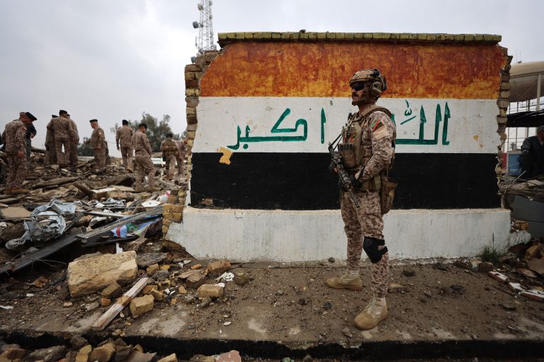 TOPSHOT - Iraqi soldiers inspect the site of a destroyed healthcare center in the Habbaniyah military base, which was targeted by in an airstrike killing seven security personnel and wounding 13 others, in Habbaniyah, west of Baghdad on March 26, 2026.