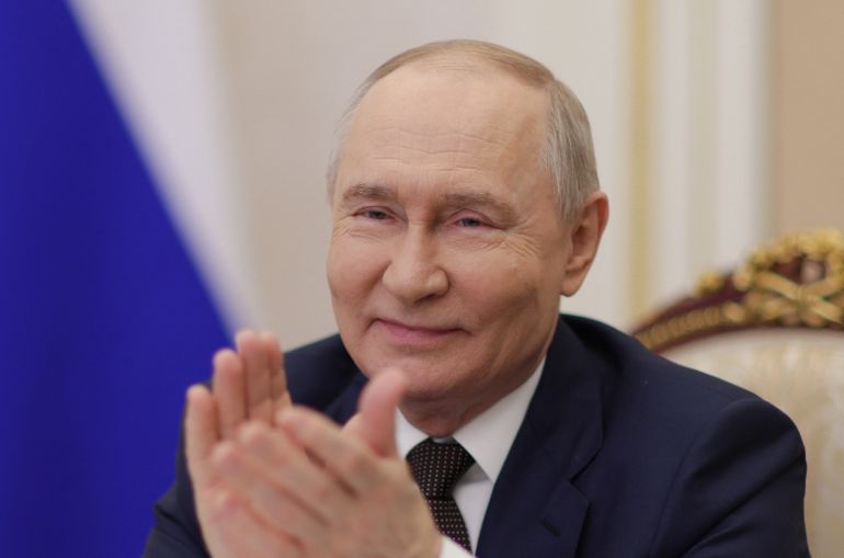 In this pool photograph distributed by the Russian state agency Sputnik, Russia's President Vladimir Putin takes part via videoconference from Moscow on March 27, 2026, in the opening ceremony of the Azerbaijan Musical and Drama Theater held in Derbent.