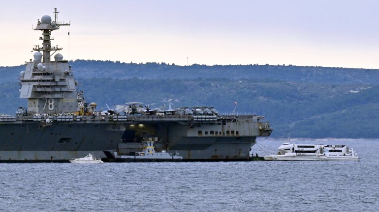 Harbour tugboats and other civilian vessels approach the U.S. Navy aircraft carrier USS Gerald R. Ford at an anchor point off the Croatian coastal city of Split on March 28, 2026, for a scheduled port visit and maintenance stop following involvement Middle East war operations. (Photo by ELVIS BARUKCIC / AFP)
