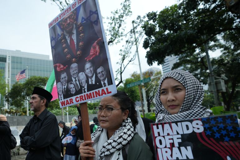 Protester hold posters during a rally against U.S. and Israel's attack on Iran and the killing of Iranian Supreme Leader Ayatollah Ali Khamenei, outside the U.S. Embassy in Jakarta, Indonesia, Monday, March 9, 2026. (AP Photo/Achmad Ibrahim)