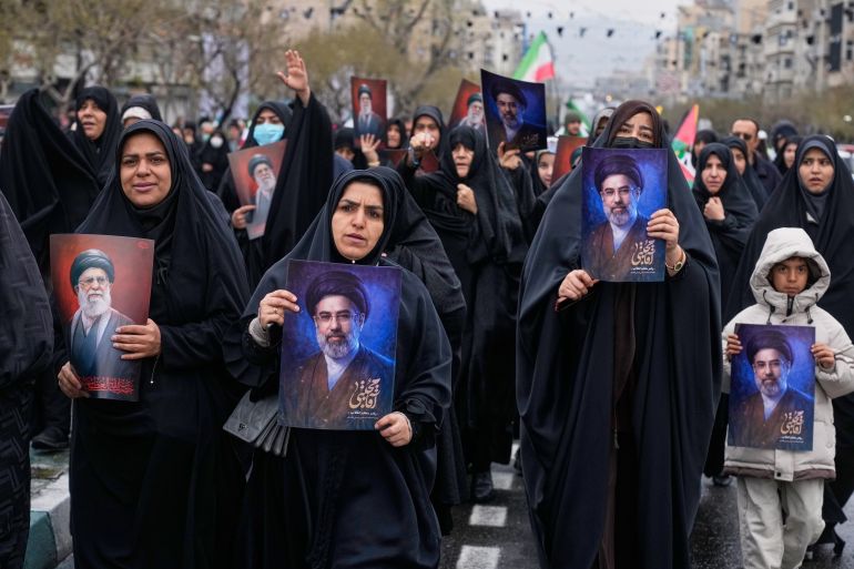 Holding pictures depicting Iran's Supreme Leader Ayatollah Mojtaba Khamenei and his late father, Ayatollah Ali Khamenei, left, demonstrators march during the annual anti-Israeli Quds Day, or Jerusalem Day, rally in support of Palestinians in Tehran, Iran, Friday, March 13, 2026. (AP Photo/Vahid Salemi)