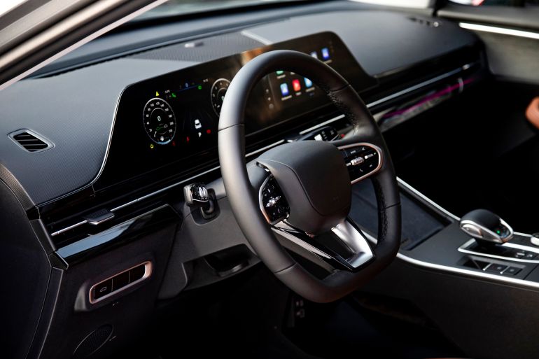 Modern luxury car interior with black dashboard and brown leather seats digital display navigation system climate control and stylish steering wheel. Premium automotive design and advanced technology