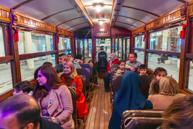 ابتسامات ركّاب داخل العربة تعكس إحساسًا جماعيًا بالاستراحة من ضجيج السياسة والأخبار.