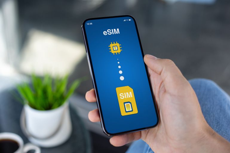 fhy6g-1771327643 Man hand hold phone with Sim card replacement on eSim on screen in cafe