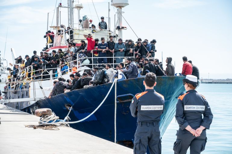 getty_68dbf05ce1-1759244380 CATANIA, ITALY - APRIL 12: Two Coast Guard soldiers watch the docking of the fishing boat with 600 migrants on board in the port of Catania on April 12, 2023 in Catania, Italy. The Italian Coast Guard escorted a fishing trawler with around 700 migrants and refugees who were rescued some 100 miles off the coast of Sicily. (Photo by Fabrizio Villa/Getty Images)