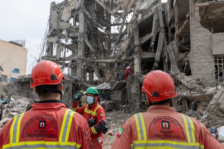 TEHRAN, IRAN - MARCH 12: Workers and civilians stand amid the rubble of residential buildings that were destroyed a few days ago following the US and Israeli attack in the eastern Tehran area on March 12, 2026 in Tehran, Iran. The United States and Israel have continued the joint strikes on Iran that began on February 28. Iran has retaliated by firing waves of missiles and drones at Israel, and targeting U.S. allies in the region. (Photo by Majid Saeedi/Getty Images)