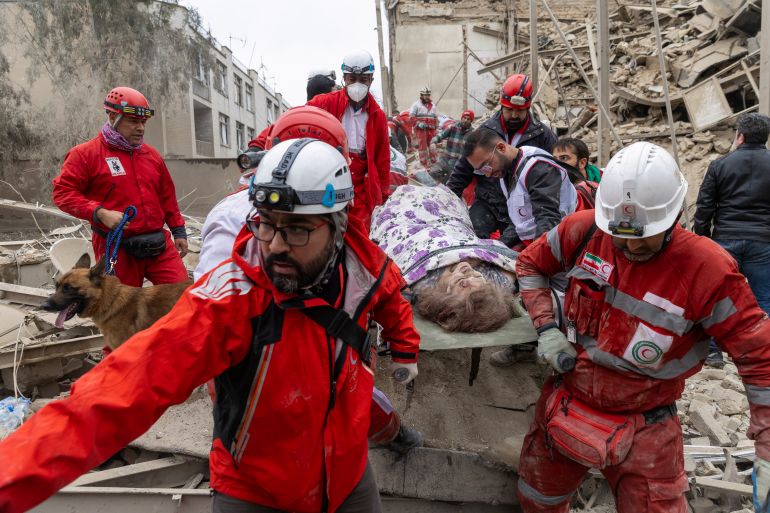 TEHRAN, IRAN - MARCH 16: Emergency workers carry an injured person on a stretcher following a strike on a residential building on March 16, 2026 in central Tehran, Iran. The United States and Israel continued their joint attack on Iran that began on February 28. Iran retaliated by firing waves of missiles and drones at Israel, and targeting U.S. allies in the region. (Photo by Getty Images)