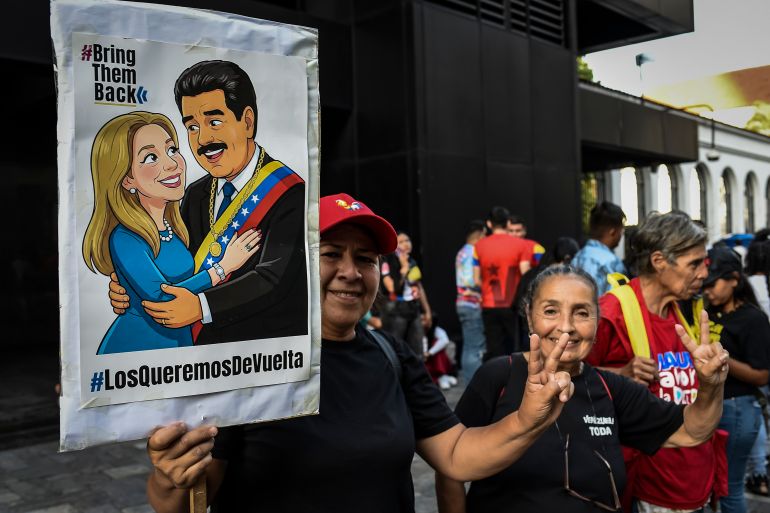 مؤيد للحكومة يرفع لافتة تحمل صورة نيكولاس مادورو وسيليا فلوريس خلال مظاهرة نُظمت في إطار إحياء يوم الشباب في فنزويلا.