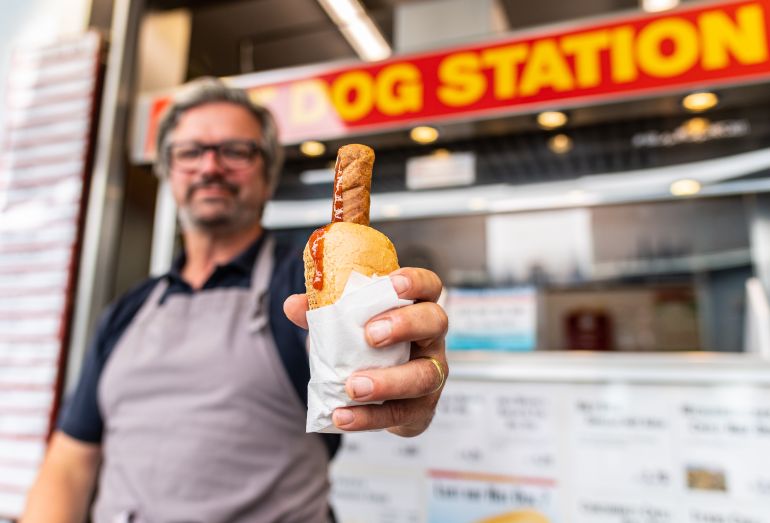 gettyimages-1241323780-1773520575 هوت دوغ ش 15 June 2022, North Rhine-Westphalia, Münster: Singer Henning Wehland ("H-Blockx") stands at a hot dog stand in Münster. The snack bar, which is popular in the student city, says it has major problems finding staff - and recently had to close for days at a time. Wehland helped out on Wednesday. He had previously announced the action on Facebook. For a week now, Münster's best-known hot dog stand in Bolandsgasse has been struggling with an acute shortage of staff and has even had to close down as a result. Photo: Guido Kirchner/dpa (Photo by Guido Kirchner/picture alliance via Getty Images)