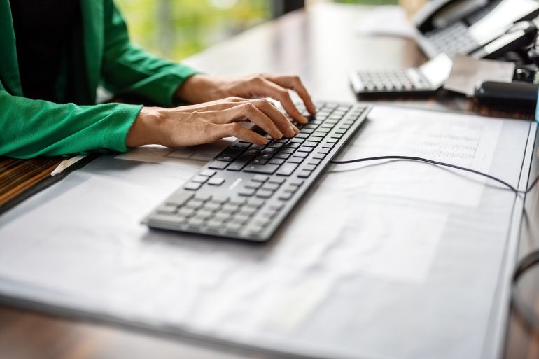 Close-up of female professional hands typing on computer keyboard. Businesswoman working at her office desk.
