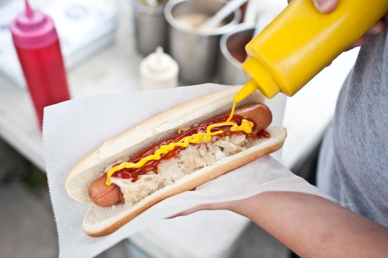 gettyimages-155096112-1773520562 هوت دوغ woman holding a hotdog out in New York City