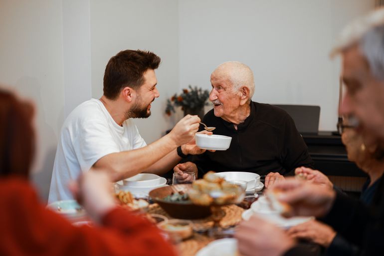 Happy Muslim family having iftar dinner together in the kitchen. A Muslim Turkish family breaks their fast at the iftar table. Iftar is the evening meal at which Muslims