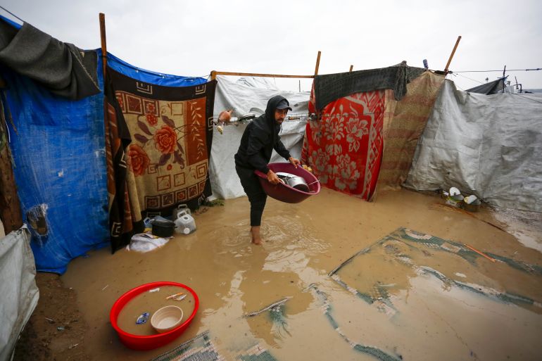 DEIR AL BALAH, GAZA - MARCH 26: Palestinians battle with cold and rainy weather that causes large water puddles and floods the makeshift tents in Deir al Balah, Gaza on March 26, 2026. (Photo by Stringer/Anadolu via Getty Images)