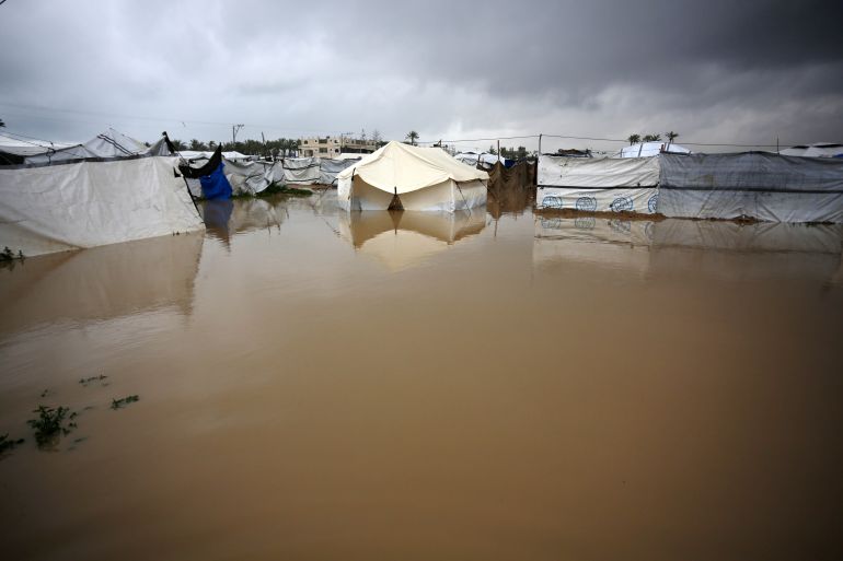 DEIR AL BALAH, GAZA - MARCH 26: Palestinians battle with cold and rainy weather that causes large water puddles and floods the makeshift tents in Deir al Balah, Gaza on March 26, 2026. (Photo by Stringer/Anadolu via Getty Images)