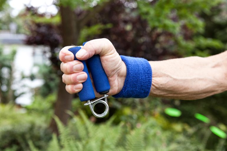 Deutschland, NRW, Garten, Senior, Sportler, Detail, Hand macht Kraftübung, Mann