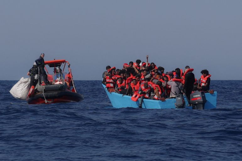 FILE PHOTO: Migrants aboard an overcrowded boat react as they are approached by German NGO Sea-Watch rescuers in the Mediterranean off Libya, August 11, 2025. REUTERS/Louisa Gouliamaki/File Photo
