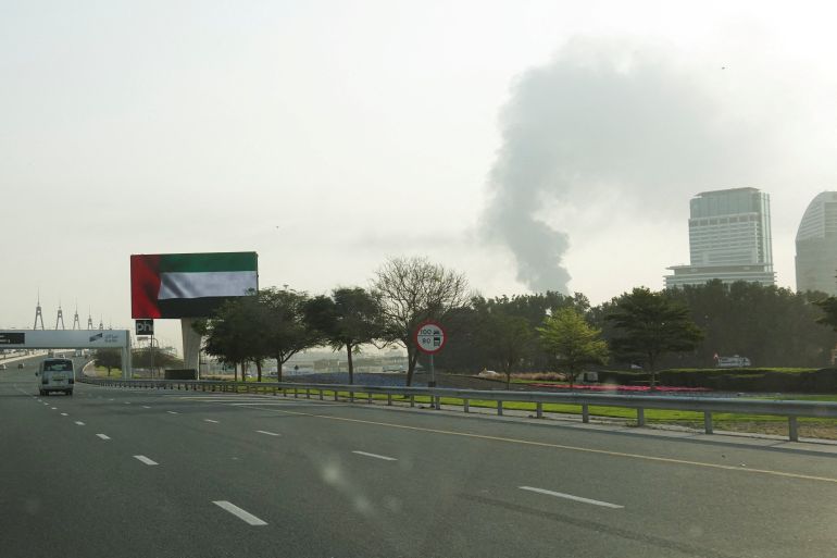 reuters_69bf5ef2-1774149362 Smoke rising from an area near the Dubai International Airport is seen through the windshield of a vehicle, after a drone attack hit a fuel tank, according to Dubai authorities, amid the U.S.-Israel conflict with Iran, in Dubai, United Arab Emirates, March 16, 2026, REUTERS/Stringer REFILE - CORRECTING FROM "SMOKE RISING FROM THE DUBAI INTERNATIONAL AIRPORT" TO "SMOKE RISING FROM AN AREA NEAR THE DUBAI INTERNATIONAL AIRPORT".