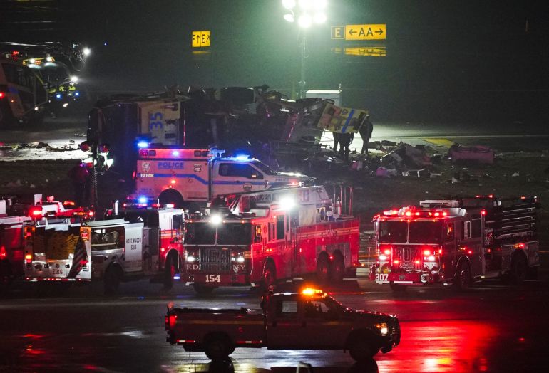 Emergency crews work around a ground vehicle following a collision between the vehicle and an Air Canada Express jet at New York's La Guardia Airport in Queens, New York, U.S. March 23, 2026. REUTERS/Bing Guan