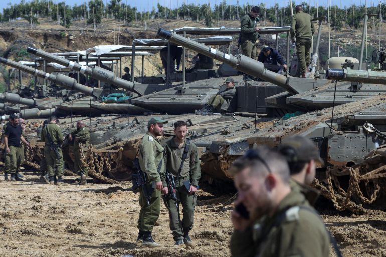 reuters_69c149b9-1774275001 Israeli soldiers stand next to tanks near the Israeli side of the border with Lebanon, amid escalation between Iran-backed Hezbollah and Israel and the U.S.-Israeli conflict with Iran, in northern Israel, March 23, 2026. REUTERS/Tyrone Siu