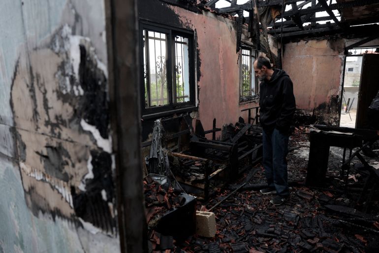 A man inspects a damaged house, which Palestinians say was burned by Israeli settlers last night, in Al-Fandaqumiya, near Jenin, in the Israeli-occupied West Bank, March 22, 2026. REUTERS/Mohammed Torokman