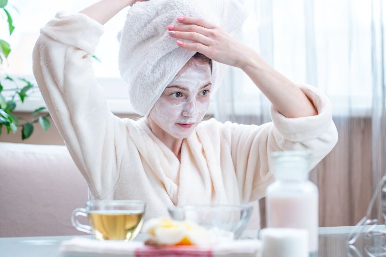 Beautiful happy young woman with natural cosmetic mask on her face. Concept skin care and Spa treatments at home