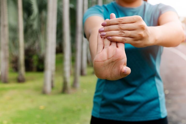 sport woman stretching forearm before exercising. outdoor sport and excercise activities concept; Shutterstock ID 1488022754; purchase_order: aj; job: ; client: ; other: