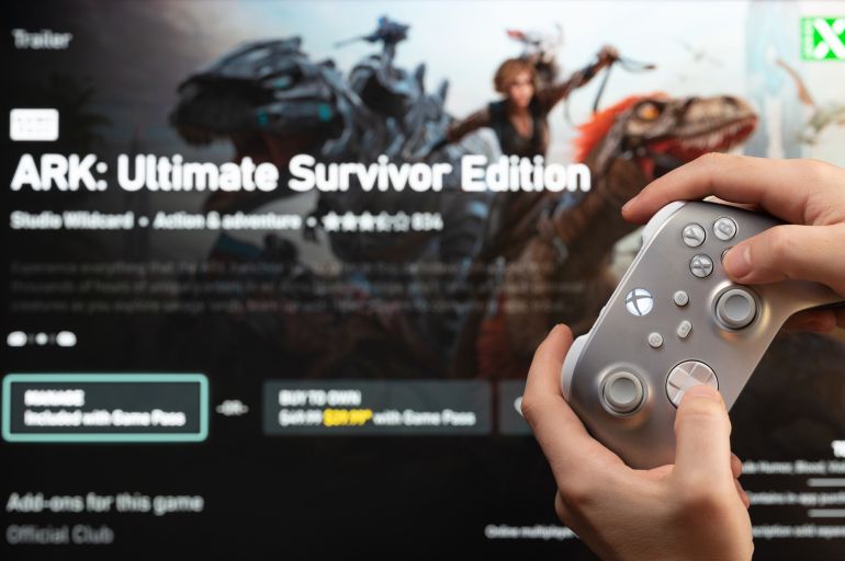 New york, USA - February 20, 2023: Buy new game ARK in online microsoft xbox store with gamepad controller in hand