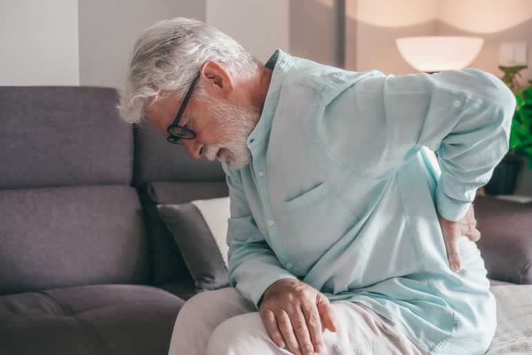 Senior elder man feel sudden back pain muscles ache tension injury at home, sad old grandfather touching spine having lower lumbago backache osteoarthritis arthritis, backache concept; Shutterstock ID 2444733427; purchase_order: aj; job: ; client: ; other: