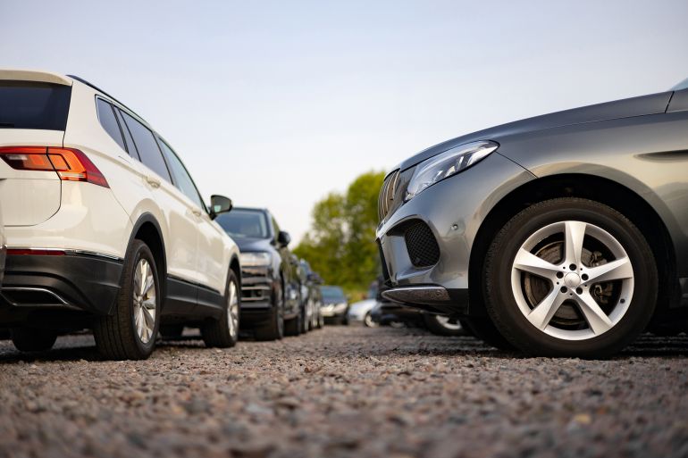 A row of various cars parked outdoors, potentially for sale or display, under a clear sky.; Shutterstock ID 2656107769; purchase_order: aj; job: ; client: ; other:
