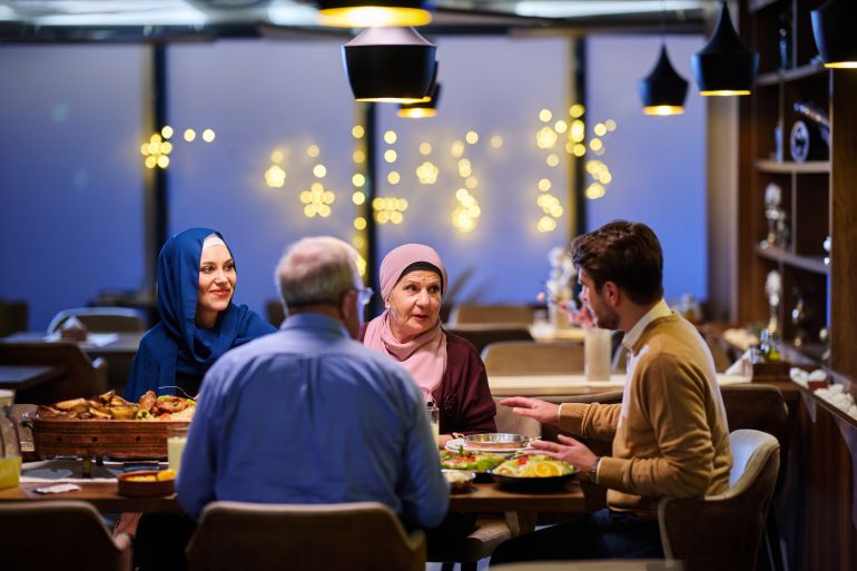 Muslim family enjoying iftar together in a restaurant decorated for Ramadan; Shutterstock ID 2719643545; purchase_order: ajnet; job: ; client: ; other: