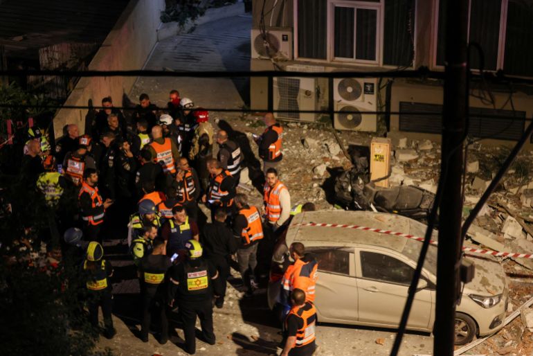 Emergency personnel gather at a damaged building following an Iranian projectile strike, amid the U.S.-Israeli conflict with Iran, in central Israel, March 18, 2026. REUTERS/Nir Elias