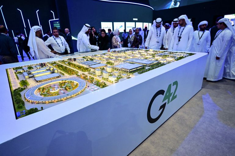 Guests look at a model of the largest data center in the UAE under construction in Abu Dhabi as the Stargate initiative, a joint venture between G42, Microsoft, and OpenAI, during the Abu Dhabi International Petroleum Exhibition & Conference (ADIPEC) in Abu Dhabi on November 3, 2025. (Photo by Giuseppe CACACE / AFP)