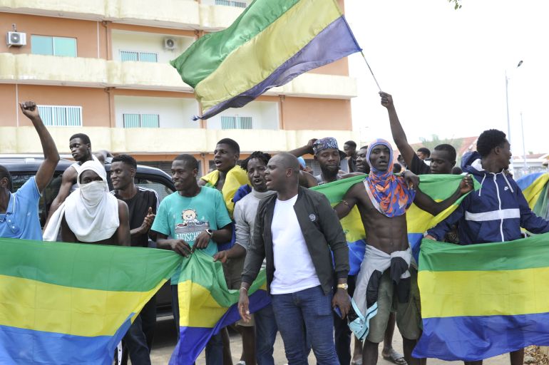 Residents holding Gabon national flags celebrate in Libreville on August 30, 2023 after a group of Gabonese military officers appeared on television announcing they were "putting an end to the current regime" and scrapping official election results that had handed another term to veteran President Ali Bongo Ondimba. - In a pre-dawn address, a group of officers declared "all the institutions of the republic" had been dissolved, the election results cancelled and the borders closed. (Photo by - / AFP)
