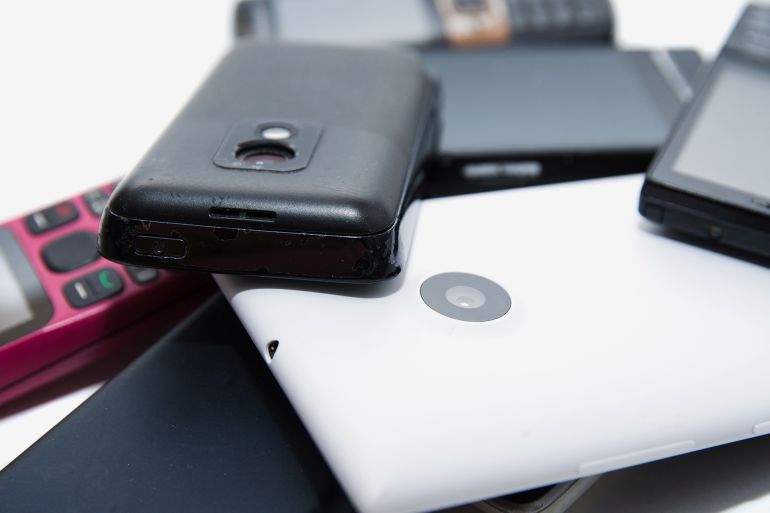 A bunch of old useless, non working, dirty, dusty and rusty cell phones. Unreasonable consumption and consumerism concept. Environment pollution concept. ... by Дмитрий Березнев ادوبي ستوك