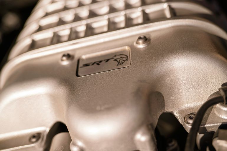 Milan, italy 28 october 2025: dodge hellcat supercharger close-up with srt logo, v8 performance engineering detail showcasing raw power and chrome muscle-car craftsmanship