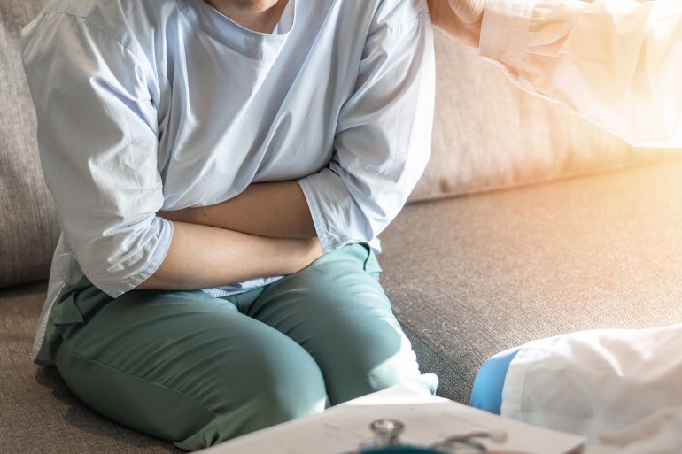Abdominal pain patient woman having medical exam with doctor on illness from stomach cancer, irritable bowel syndrome, pelvic discomfort, Indigestion, Diarrhea, GERD (gastro-esophageal reflux disease)