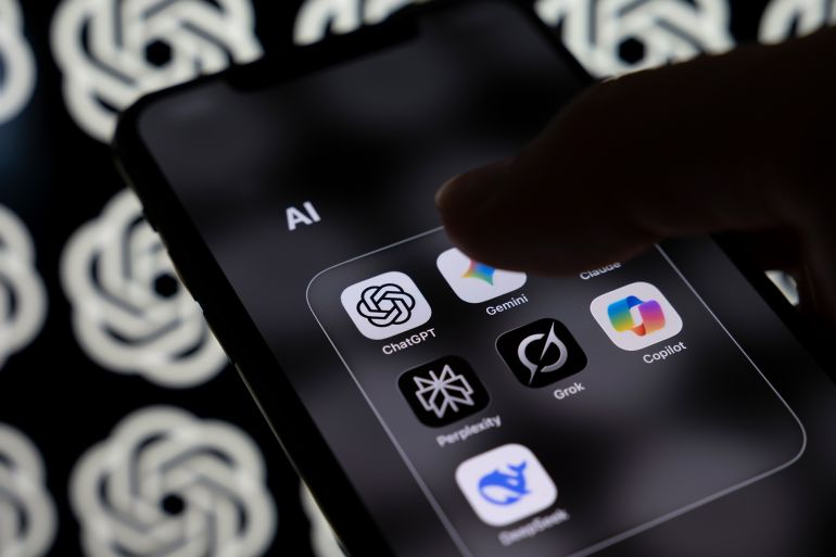 6d982d981d8bad8a7d984d989d8b1d984d8a7-1771498669 A smartphone screen displays a folder containing the AI applications Claude, ChatGPT, Gemini, Perplexity, Grok, Copilot, and DeepSeek with a multitude of OpenAI logos in the background. OpenAI announces the release of GPT-5.3-Codex, its most advanced agentic coding model to date, in Creteil, France, on February 6, 2026. (Photo by Samuel Boivin/NurPhoto via Getty Images)