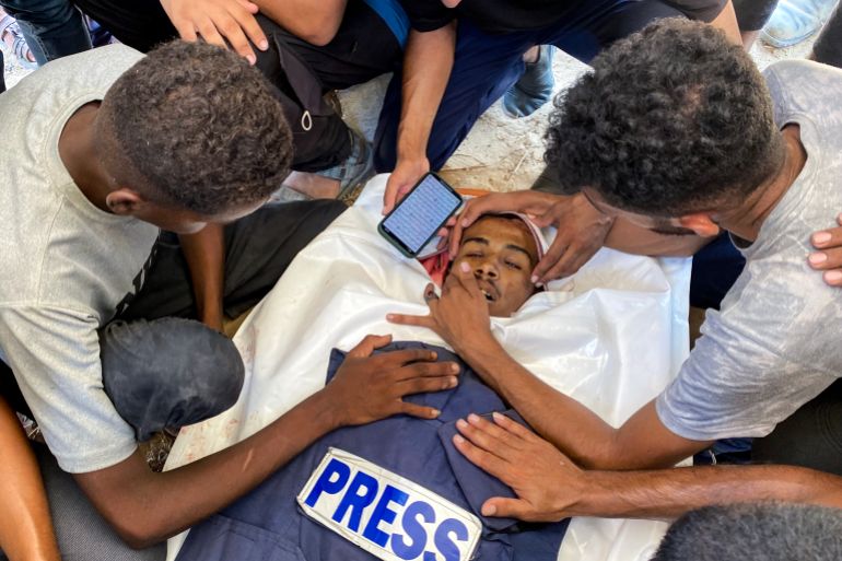 afp_68ac5ff85972-1756127224 Relatives of Palestinian Al-Jazeera photojournalist Mohamed Salama, who was killed in an Israeli strike on Nasser Hospital, mourn over his body ahead of his funeral in Khan Yunis in the southern Gaza Strip on August 25, 2025.
