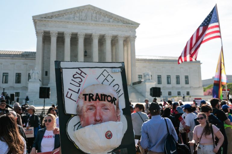 An anti-Trump sign is displayed as demonstrators rally outside the US Supreme Court as President Donald Trump attends oral arguments in Washington, DC on April 1, 2026.