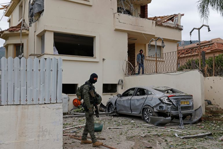 An Israeli security personnel stands guard at the site of a Hezbollah missile strike that targeted a house in the northern Israeli town of Kiryat Shmona near the border with Lebanon on April 1, 2026.