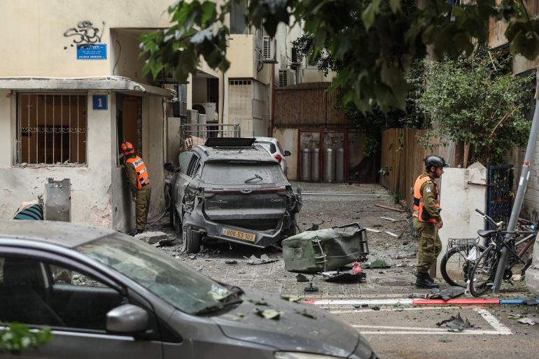 First responders work at the site of an impact in a residential neighbourhood of Tel Aviv following an Iranian strike, on April 1, 2026.