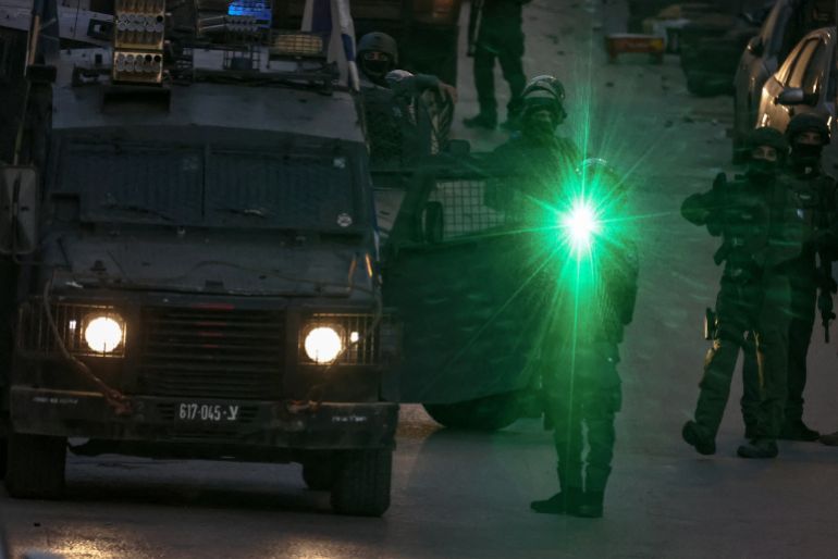 Members of Israeli security forces stand guard during a military raid in the neighbourhood of Kafr Aqab some 16 kilometres south of the city of Ramallah, in the Israeli-occupied West Bank on April 5, 2026.