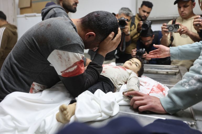 EDITORS NOTE: Graphic content / A relative mourns over the body of three-year-old Yahya al-Malahi, who was killed in an Israeli strike ahead of her funeral in Gaza City on April 14, 2026.