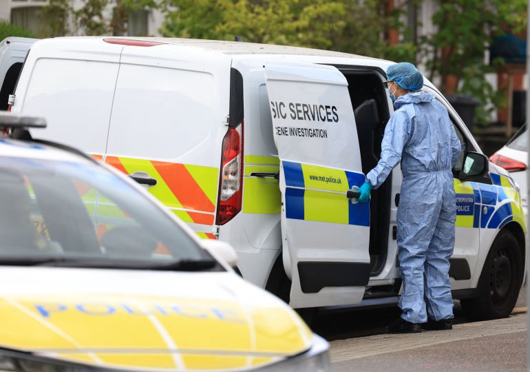 A forensics officer stands at a police van during an investigation into an attack in the early hours of the morning on the Finchley Reform Synagogue, in the North Finchley area of north London, on April 15, 2026.