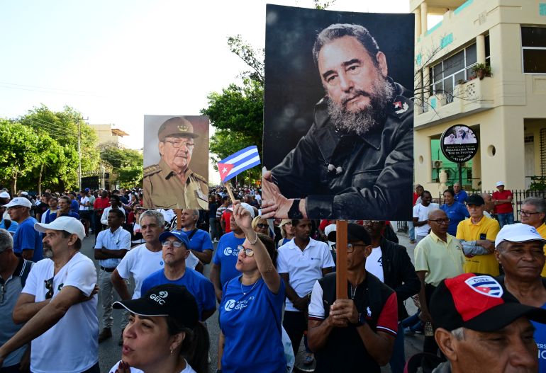 People hold pictures of late leader Fidel Castro and his brother, former president Raul Castro, during celebrations marking the victory on the 65th anniversary of the Bay of Pigs invasion and the declaration of the socialist character of the Cuban Revolution in Havana on April 16, 2026.