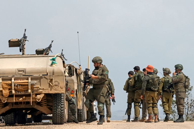 Israeli army soldiers stand next to their humvees as they patrol along the border with southern Lebanon, in the Upper Galilee of northern Israel on April 17, 2026.