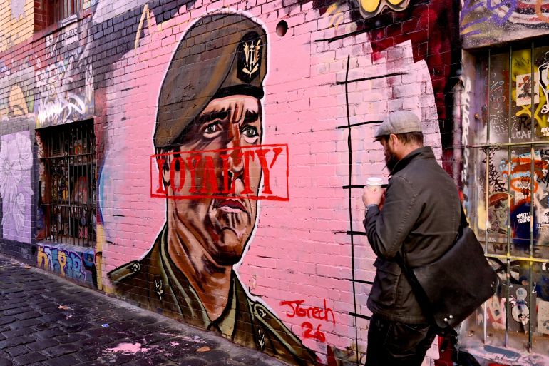 A man walks past a street mural by artist Jarrod Grech of former Australian SAS soldier Ben Roberts-Smith, in Melbourne on April 17, 2026.