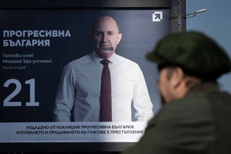 Pedestrians walk past an electoral billboard of the Progressive Bulgaria coalition's leader and former President Rumen Radev in Sofia on April 17, 2026.